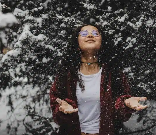 woman in white shirt touching the snow