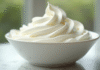 Bol rempli de creme chantilly bien ferme en gros plan