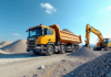 Camion plateforme déchargeant du gravier sur un chantier